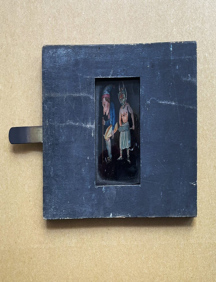 Item #5385 Plaque de lanterne magique &agrave; syst&egrave;me, repr&eacute;sentant un diable purgeant un homme portant un bonnet et tenant une canne. PRE-CINEMA.